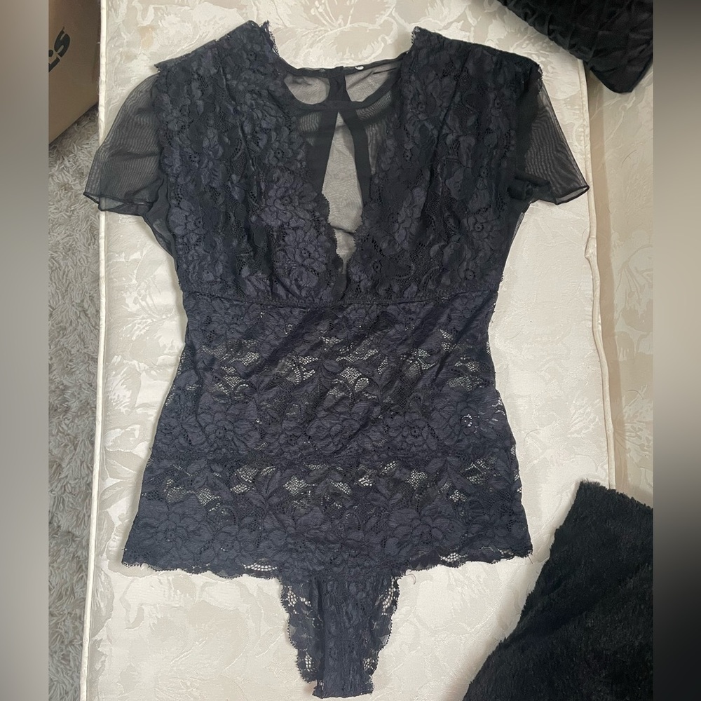 Lacey black short sleeve body suit with mesh deep V. It has four buttons in back